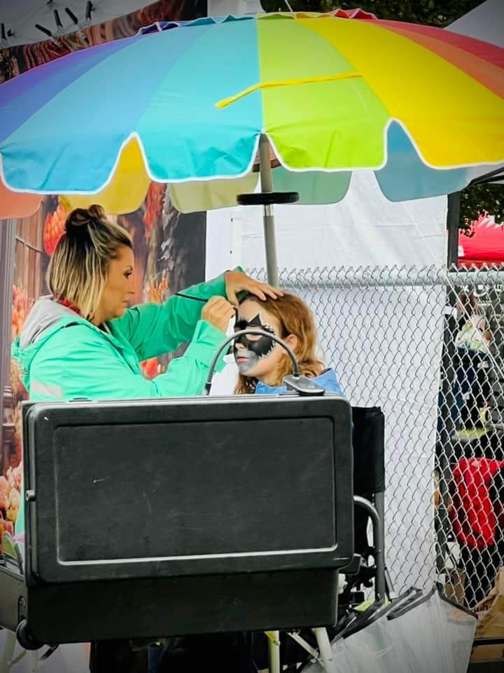 Painting a child's face at an outdoor festival