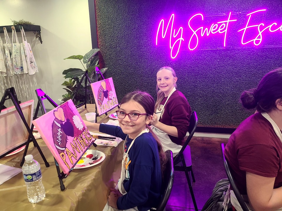 Friends painting together at a paint party in the studio