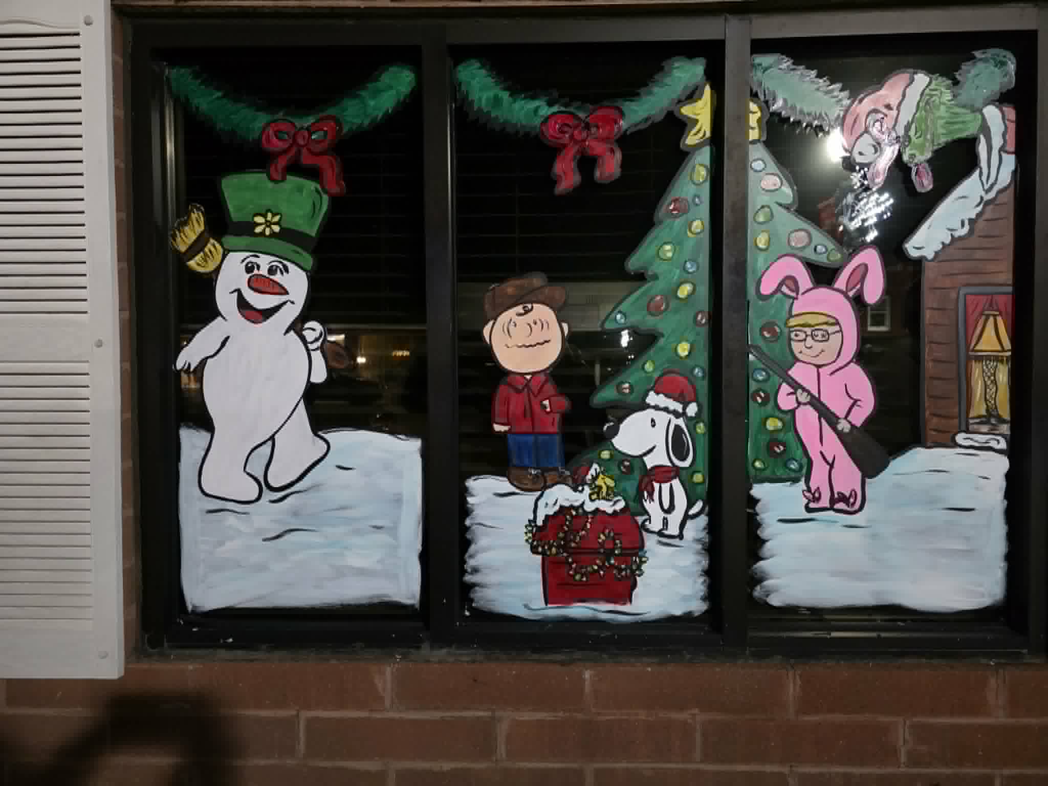 Festive painted holiday windows with snowman and Peanuts characters