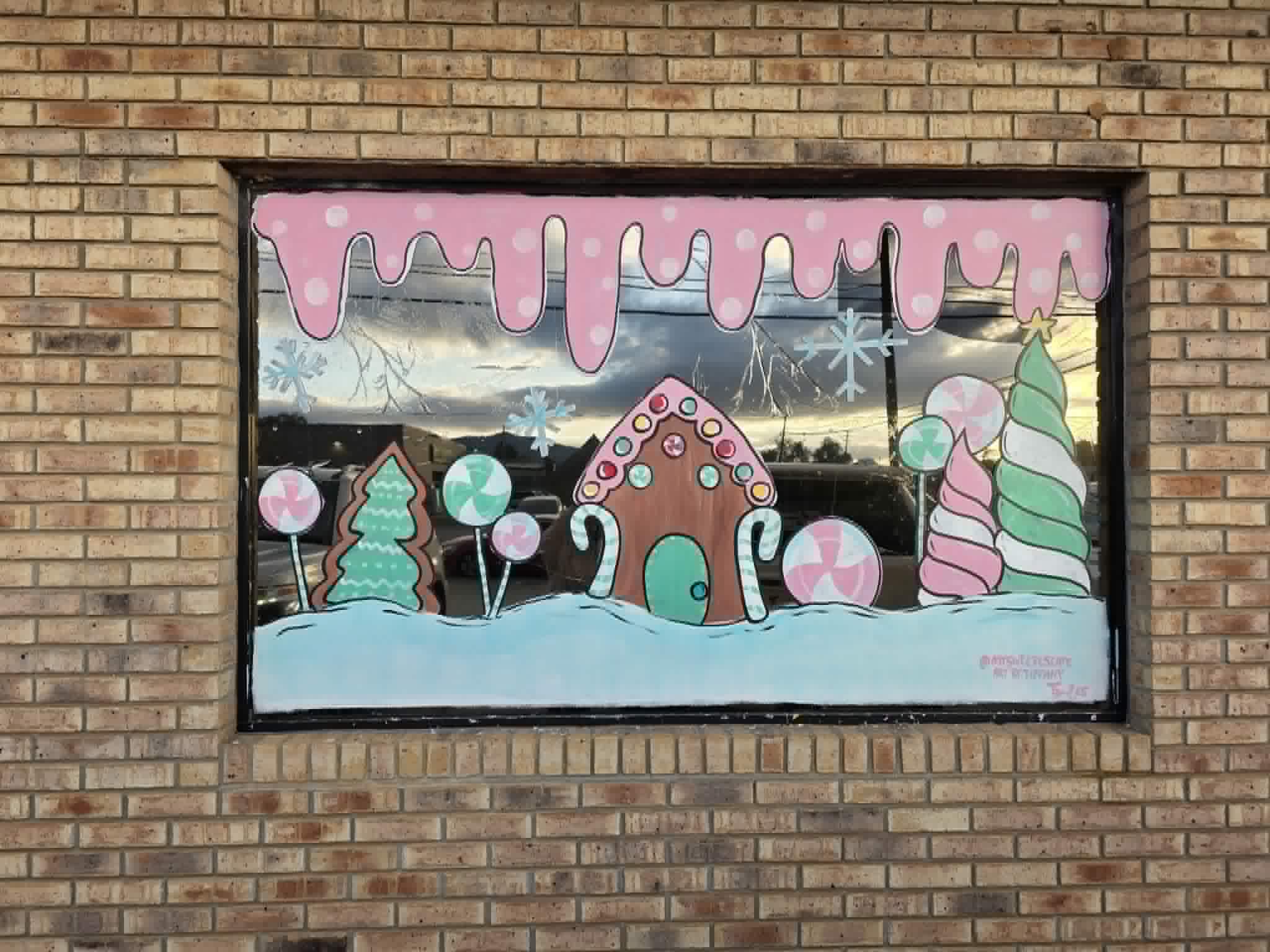 Painted gingerbread house and candy details on a brick storefront